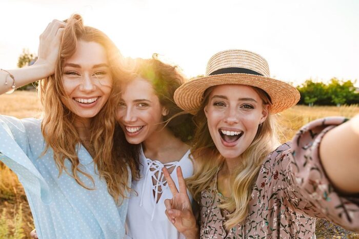 Photo of joyful caucasian women taking selfie photo