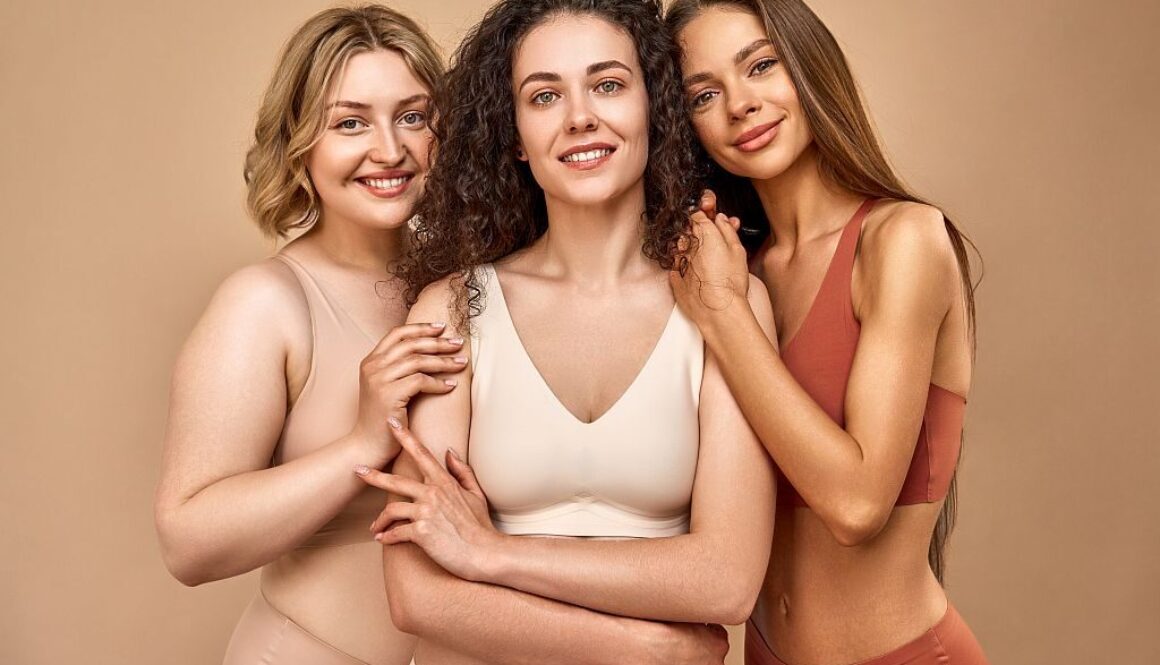 The power of women.Three different women in underwear are looking at the camera and smiling. In the middle, a curly-haired woman stands with her arms crossed, on the sides a blonde and a brunette.